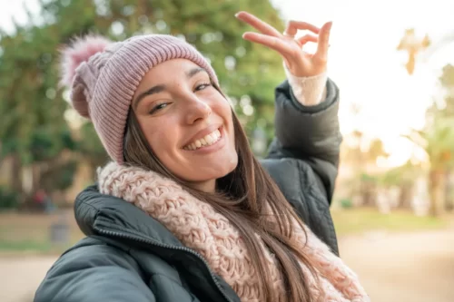 Jeune belle femme souriante et posiive prenant une photo de selfie