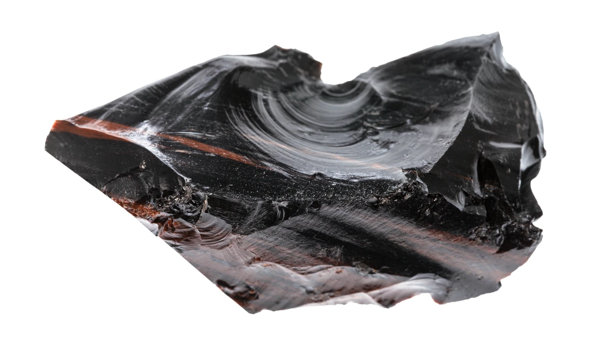 Un morceau d'obsidienne noire aux reflets brillants et aux nuances de couleur sur un fond blanc isolé.